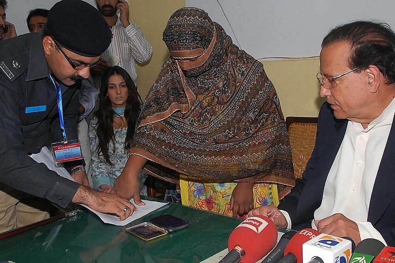 Pakistani Christian Asia Bibi putting her thumb impression as a signature on the appeal papers against her death sentence in 2010. Pakistan's Supreme Court upheld its decision to acquit the farm worker of blasphemy charges yesterday.