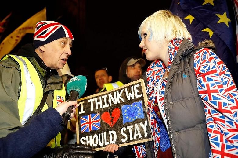 A pro-Brexit activist (left) and an anti-Brexit activist demonstrating outside the Houses of Parliament on Tuesday. Britain is legally on track to leave the European Union with or without a deal on March 29, unless it delays or stops the process.
