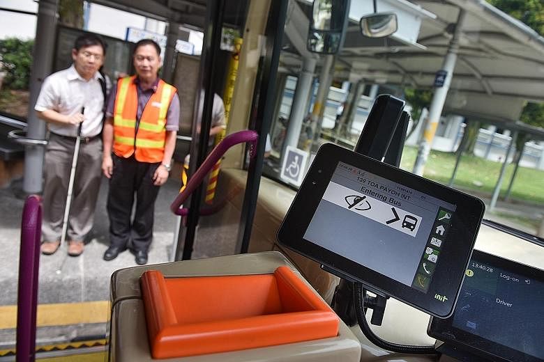 A wheelchair-bound commuter using the app to alert the bus driver that he wants to board the bus at the bus stop. Above: Mr Chong Kwek Bin getting ready to board the bus with the bus driver's help. Left: A sign on the bus about a hearing-aid feature 