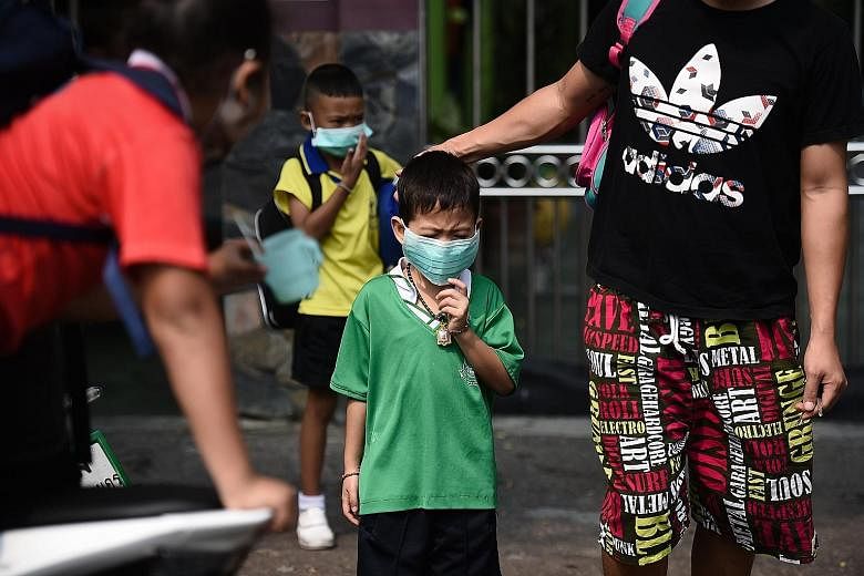 Children wearing face masks leaving their school early due to air pollution in Bangkok on Wednesday.