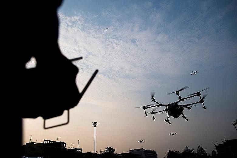 Drones used by the Bangkok authorities yesterday to disperse water to help clear the air of the harmful microscopic particles known as PM2.5. The move drew scepticism and derision from Thai social media users.
