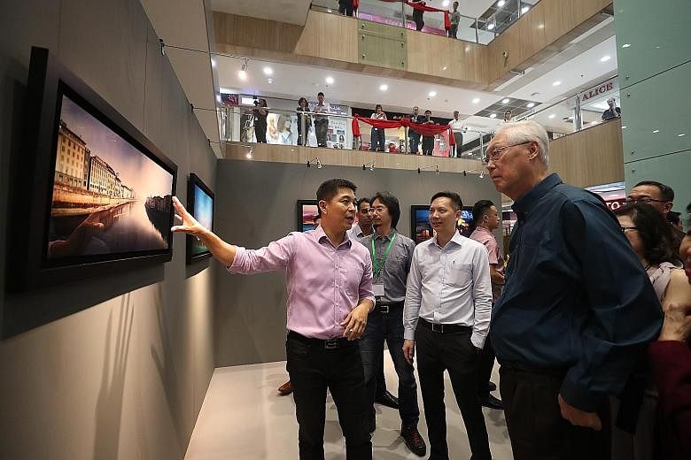 (From left) Parliament Speaker Tan Chuan-Jin with Hope Initiative Alliance's Reverend Ezekiel Tan and Emeritus Senior Minister Goh Chok Tong as they viewed Mr Tan Chuan-Jin's works at Far East Plaza yesterday. The money raised from the photo exhibiti