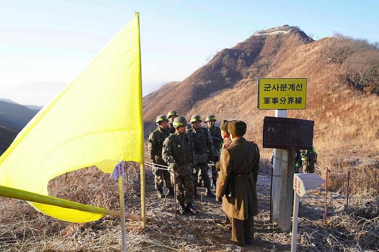 South Korean soldiers (left) being greeted by North Korean soldiers in Cheorwon county before crossing the Military Demarcation Line last December to inspect a dismantled North Korean guard post inside the Demilitarised Zone dividing the two Koreas.