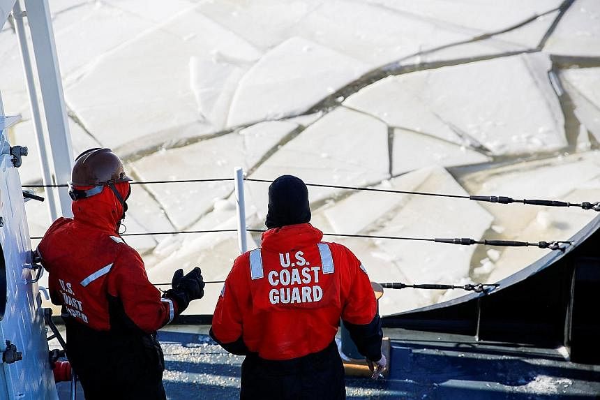 An official of the Salvation Army hugging a homeless person during a cold wellness check-up in Chicago on Thursday. US Coast Guard staff using a boat as an ice breaker on the Hudson River, between the towns of Kingston and Poughkeepsie, in New York, 