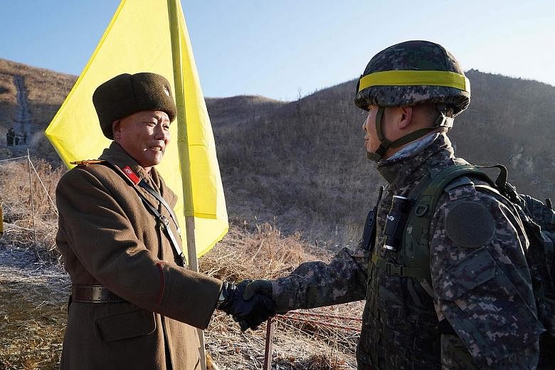 A South Korean soldier (far right) meeting a North Korean one before crossing the Military Demarcation Line last December to inspect a dismantled North Korean guard post inside the Demilitarised Zone dividing the two Koreas in Cheorwon.