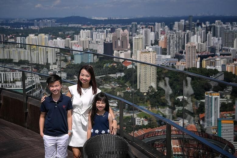 ERA division director Wendeline Goh, with her children - Brandon, 11, and Amelia, seven - at the rooftop of her condominium Skysuites@ Anson. She says the panoramic view of the city from her 68th-floor unit is breathtaking. Ms Goh says her apartment 