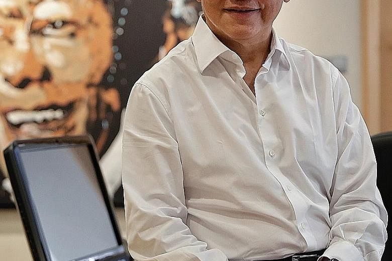 Mr Liew Mun Leong at his office in Changi Airport. In the background is a portrait of Singapore's founding prime minister Lee Kuan Yew, painted by French artist Jean-Pierre Blanchard.