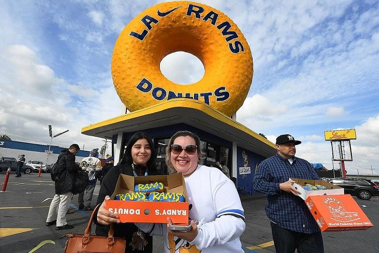 LA Rams fans Katelyn (left) and Nancy Delgado show their team-themed donuts on Friday, ahead of today's Super Bowl final.