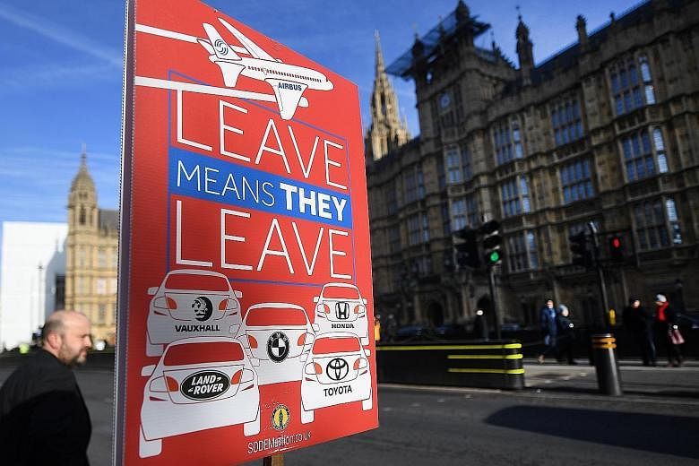 An EU campaign placard outside the Houses of Parliament in London warning that leaving EU would lead to an exit of the car industry and Airbus from Britain.