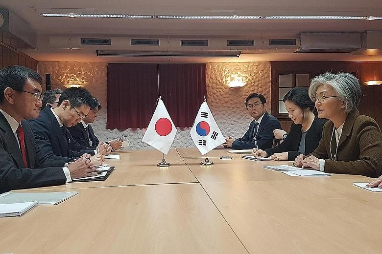 Japanese Foreign Minister Taro Kono (far left) meeting his South Korean counterpart Kang Kyung-wha (far right) on the sidelines of the World Economic Forum, in Davos, Switzerland, last month. The feud between both countries is beginning to damage eco