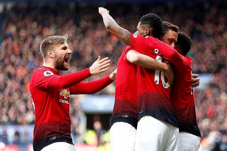 Manchester United forward Marcus Rashford (No. 10) celebrating scoring his goal with Luke Shaw and other teammates yesterday as the Red Devils beat Leicester 1-0 to keep their hopes of a top-four finish alive. Below: The striker opened the scoring in