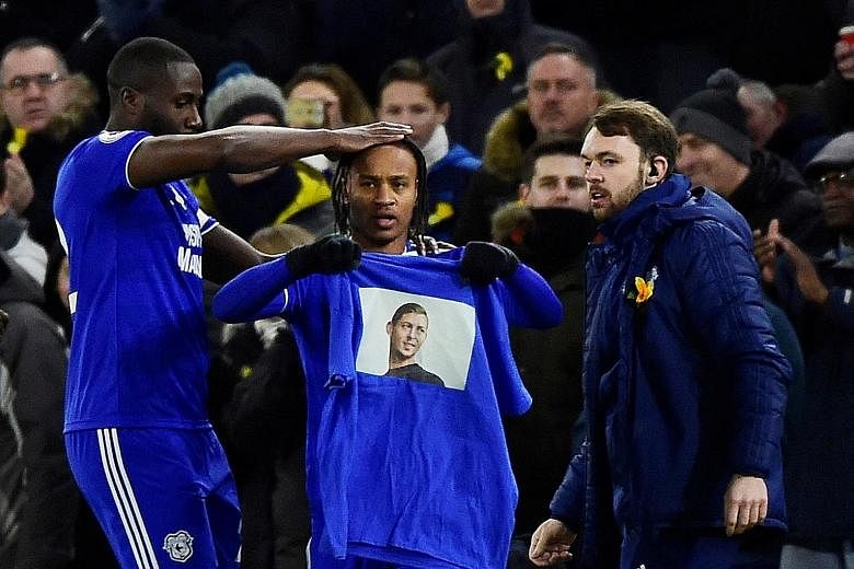 Cardiff City's Bobby Reid celebrates scoring their first goal against Bournemouth last Saturday by displaying a shirt paying tribute to Emiliano Sala.