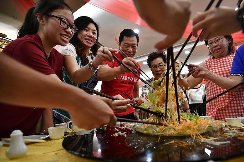 Madam Siah Choo Ing (fourth from left), 79, tossing yusheng with (from left) her granddaughter Krystal Low, 17, daughter-in-law Katharine See, 50, son Kenny Low, 51, and daughter Irene Low, 52, during their reunion lunch at Swatow Seafood restaurant 