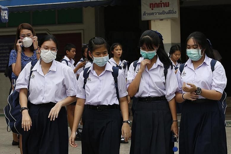 Students wearing masks as heavy air pollution continues to affect Bangkok. A rattled Thai government is stepping up oversight of factories.
