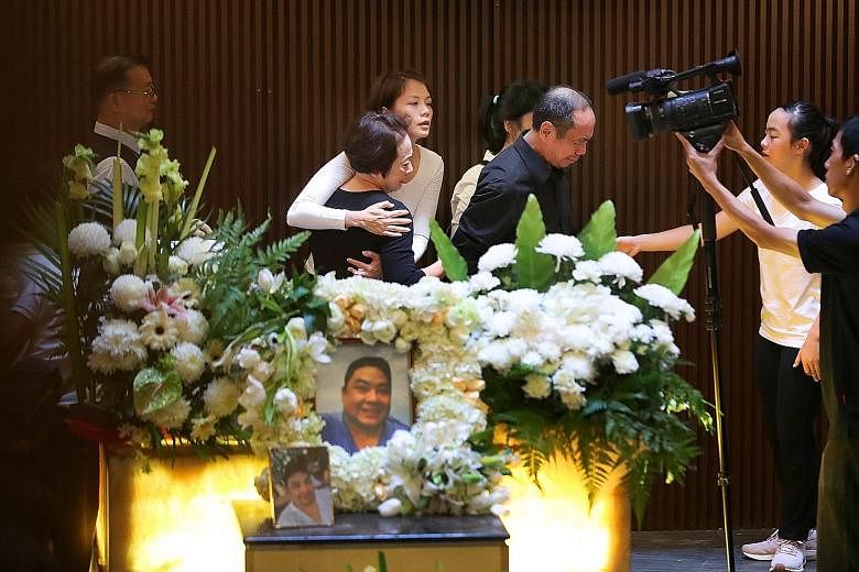 Mr Ben Goi's parents, Sam and Jacqueline Goi (both centre, in black), and wife, Ms Tracy Lee (embracing Mrs Goi), at the funeral service in Mandai Crematorium yesterday.