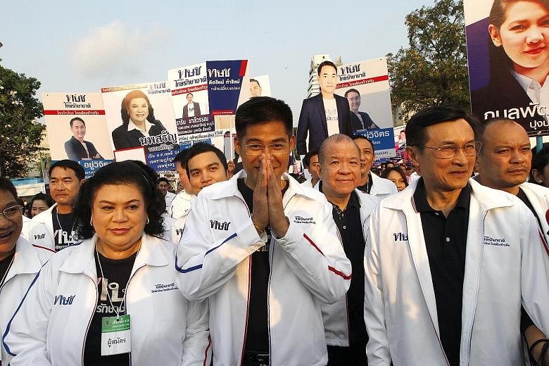 Thai Raksa Chart political party leader Preechapol Pongpanich (centre), and party member Chaturon Chaisang (right) on the campaign trail.