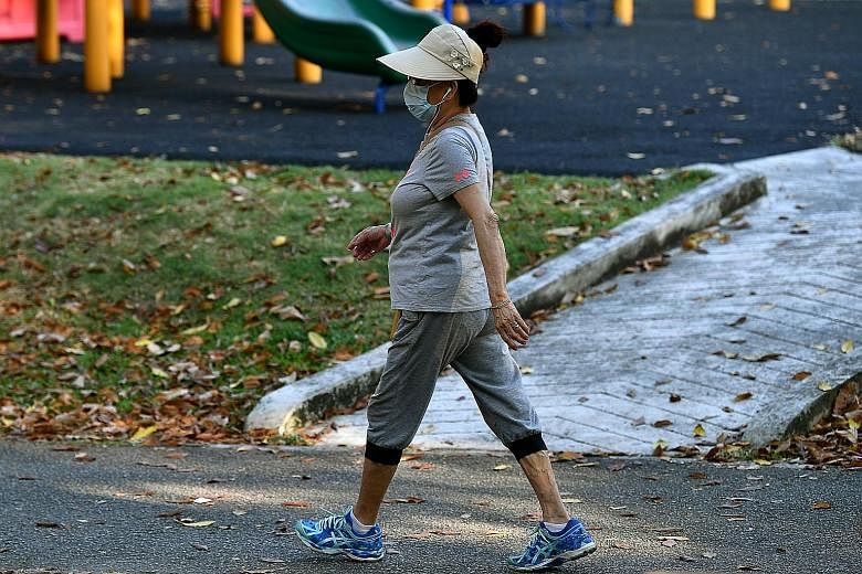 A woman wearing a face mask while out walking in Tampines Central Park at around 8.30 yesterday morning. NEA said the one-hour PM2.5 readings in the east from 8am to 11am were in the "elevated" range - from 46 to 62 mcg/m3. The air around Tampines Ce
