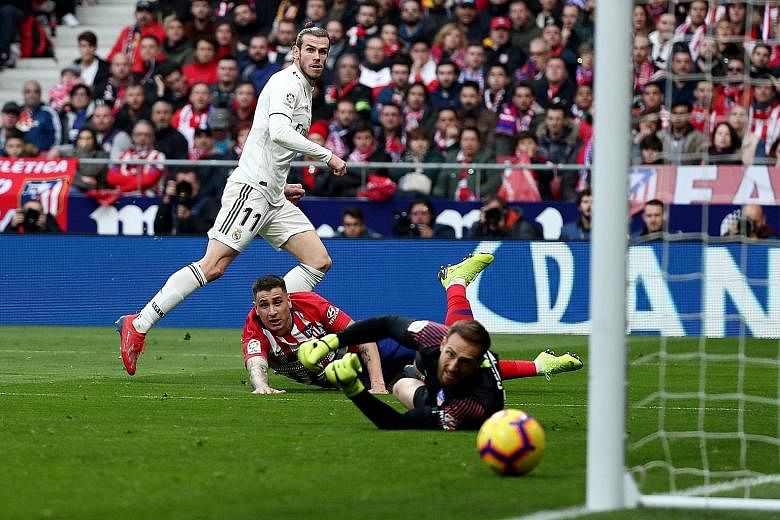Gareth Bale scoring Real Madrid's third goal past the despairing lunges of Jose Gimenez and goalkeeper Jan Oblak. The goal against Atletico Madrid on Saturday was his 100th for Real.