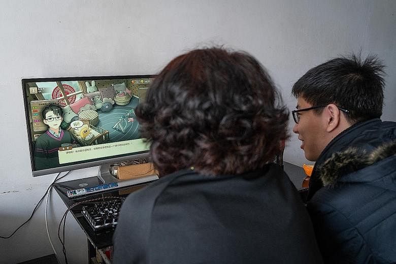 Mr Kang Shenghao, 19, playing the video game Chinese Parents with his mother.