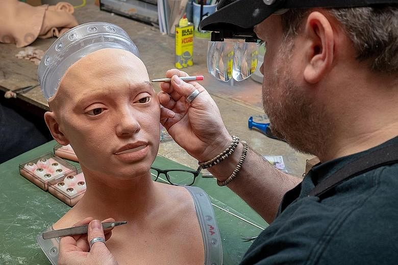 The rubberised head of Ai-Da, a humanoid robot capable of drawing people from life using her bionic eyes and hand, is given life-like features by Mr Mike Humphrey from robotics company Engineered Arts.