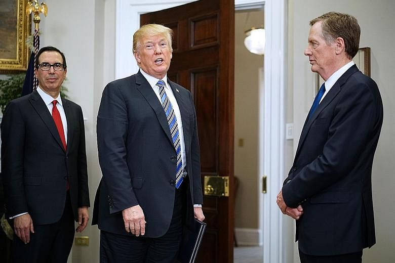 US Treasury Secretary Steven Mnuchin (left) and Trade Representative Robert Lighthizer flanking President Donald Trump. The two Trump officials are scheduled to meet President Xi Jinping in Beijing tomorrow. Mr Trump has indicated a willingness to gi