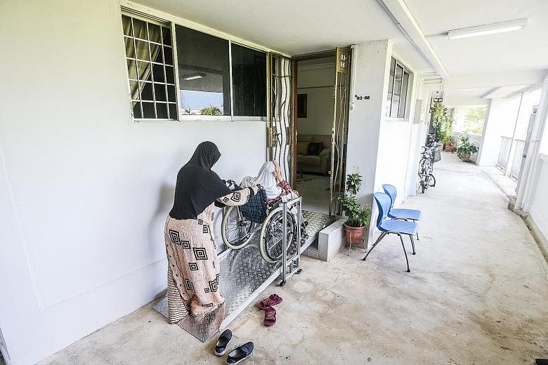 Ms Diana Norahman helping her mother up a customised fixed ramp installed at their HDB flat entrance. While the Government is looking at building more integrated developments, many seniors prefer to age in familiar surroundings, noted Senior Parliame