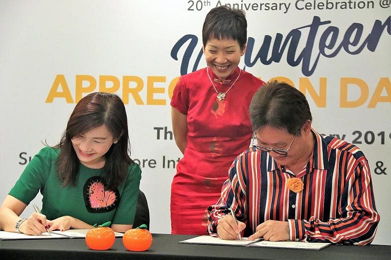 Standard Chartered Bank regional head of corporate affairs and branding and marketing Eva Ang and RSVP Singapore chairman Koh Juay Meng signing the memorandum of understanding yesterday, witnessed by Minister for Culture, Community and Youth Grace Fu
