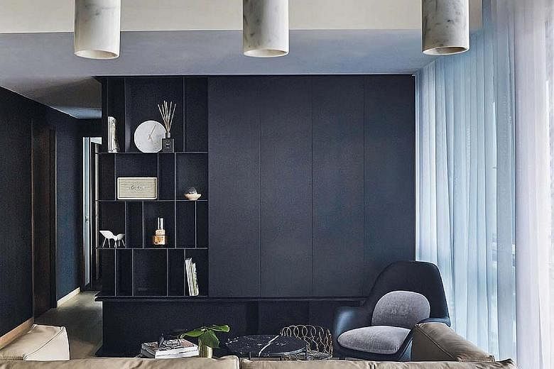 Wood furniture, such as the Bolia Bird dining chairs, as well as plants give the home pops of colour. The colour black is seen throughout the home, such as on the feature walls in the living room (above) as well as kitchen cabinets (top).