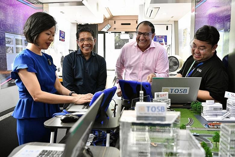 Mr Iswaran (far right), who is also in charge of cyber security, with Senior Minister of State for Communications and Information Sim Ann and Senior Minister of State for Defence Maliki Osman on the Infocomm Media Development Authority's Lab on Wheel