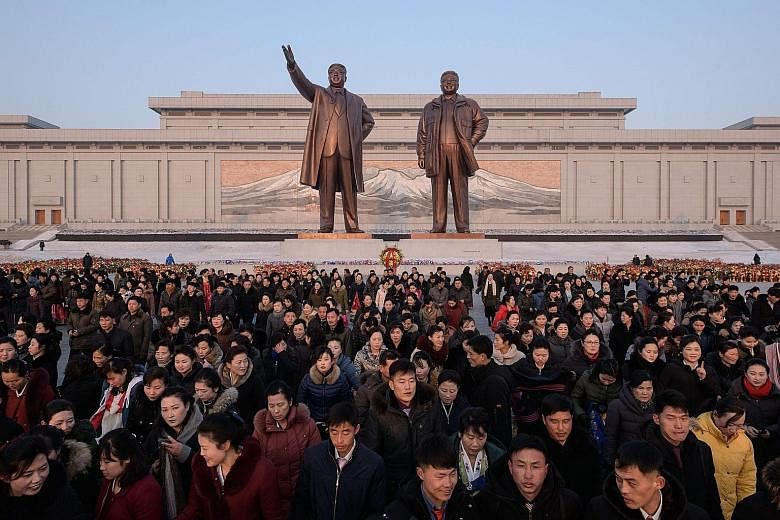 North Koreans paying their respects in Pyongyang yesterday before the statues of their late leaders Kim Il Sung and Kim Jong Il as part of celebrations marking the latter's birthday.