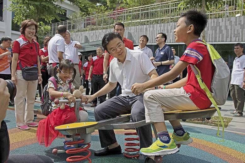 Minister for National Development Lawrence Wong with children on the rooftop of Oasis Terraces yesterday. The mall in Punggol has community gardens and a fitness corner on the roof, as well as 106 shops.