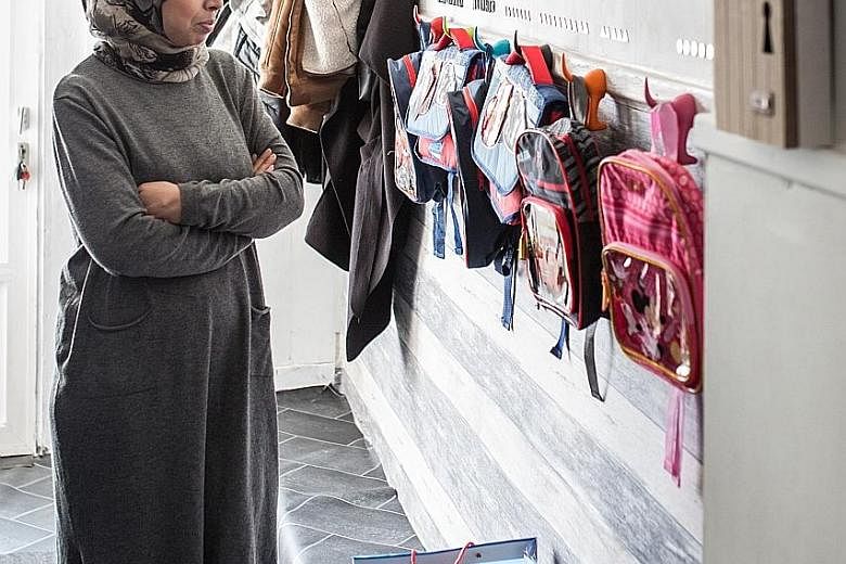 Ms Fatiha looking over the backpacks she has prepared for her six grandchildren at her home in Ranst, Belgium. A "Spider-Man" bedsheet and teddy bears (far left) on one of the beds she has ready. But there is no knowing if and when the children - now