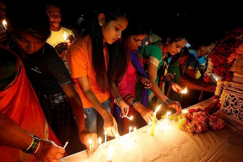 People lighting candles at a memorial during a vigil on Tuesday to pay tribute to those killed in last Thursday's terror attack in Kashmir.
