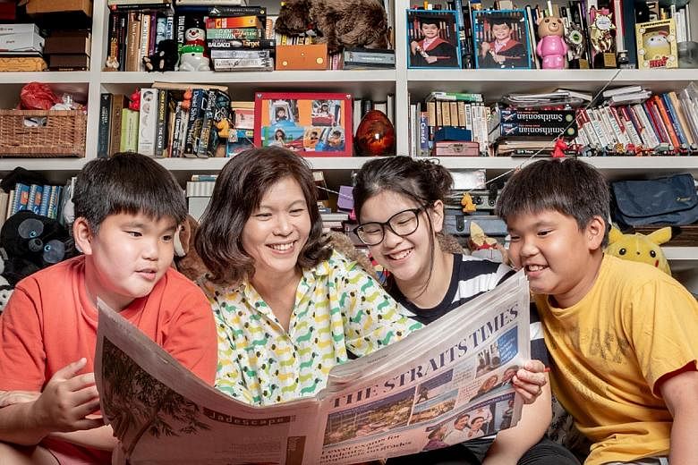 Housewife Lee Cheng Huan with her daughter Sarah and twin sons Timothy (in yellow) and Thomas. The Lee family are the first to be featured in the #readwithST campaign, which started yesterday. Mrs Lee has been cutting and pinning up news stories for 