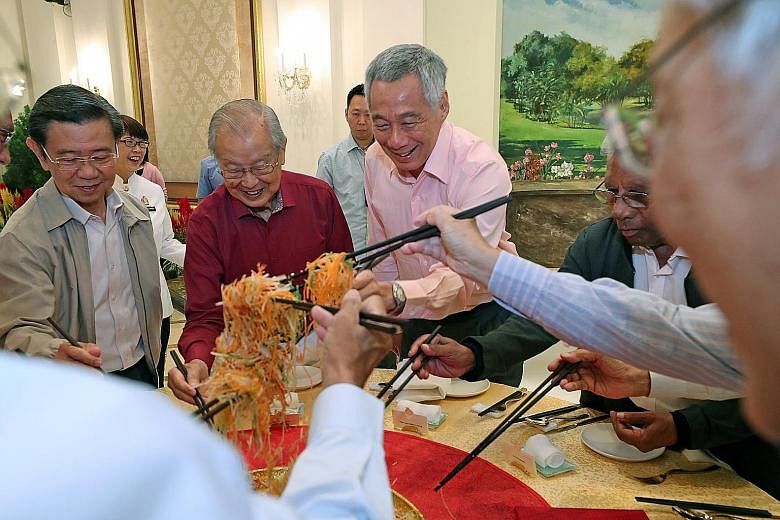 Prime Minister Lee Hsien Loong tossing yusheng with (from far left) former deputy prime minister Wong Kan Seng, first-generation leader Ong Pang Boon and former Cabinet minister S. Dhanabalan at the Istana on Tuesday. PM Lee was hosting several gener
