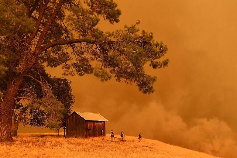 Firefighters battling a wildfire in California last July. The writer says the world is at a point where alarmism and catastrophic thinking over climate change are valuable.
