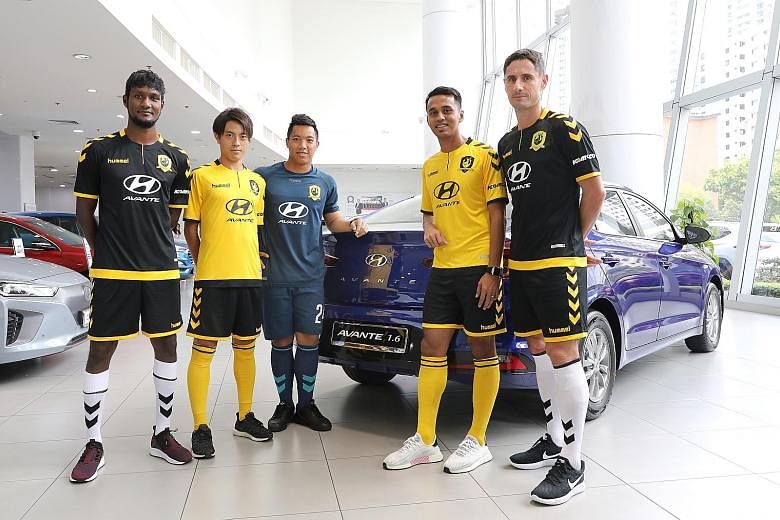 Tampines Rovers players posing beside the Hyundai Avante at the Hyundai Showroom yesterday. Komoco Motors will be the new sponsor of SPL club Tampines Rovers.