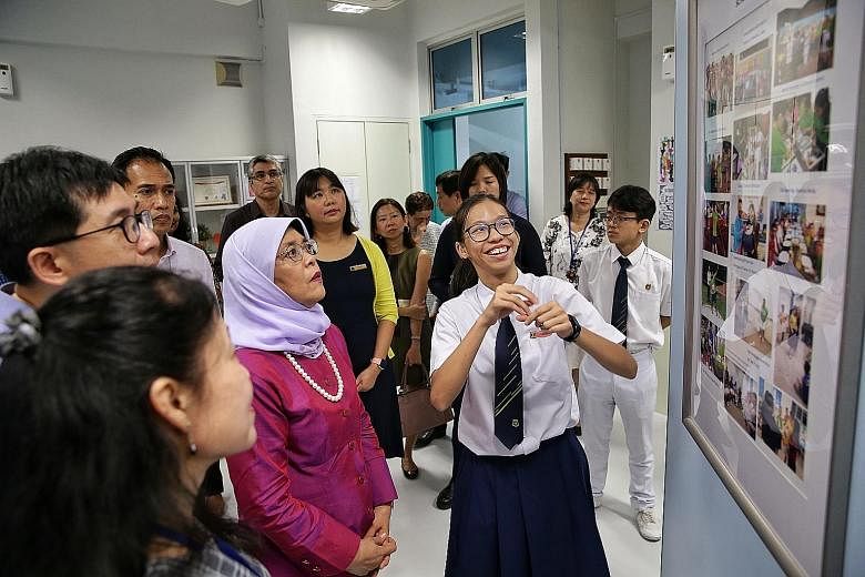 President Halimah Yacob being briefed by Secondary Four Normal Technical hearing loss student Khoo Si Tian, 18, during a tour of Beatty Secondary School's specialised room yesterday.