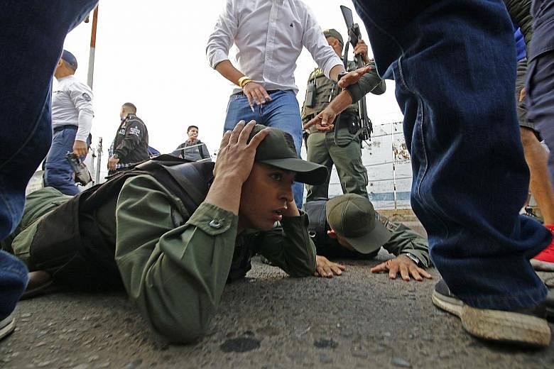 Venezuelan soldiers being held after driving into Colombia from the Venezuelan side of the Simon Bolivar International Bridge in Cucuta yesterday. President Nicolas Maduro's government has closed bridge crossings on the frontier being used by protest