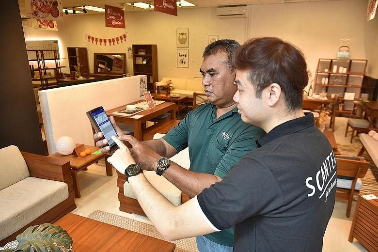 A manager and delivery man checking the routes on the delivery automation application at the Scanteak furniture showroom in Sungei Kadut. It used to take staff at the furniture retailer around two hours a day to plan the routes. The adoption of the a