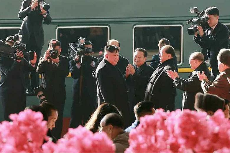 Above: Some 100 bodyguards for North Korean leader Kim Jong Un arriving yesterday at Noi Bai International Airport in Hanoi, Vietnam, on a North Korean cargo plane ahead of the summit. Right: Mr Kim Jong Un (centre) being sent off by his top official