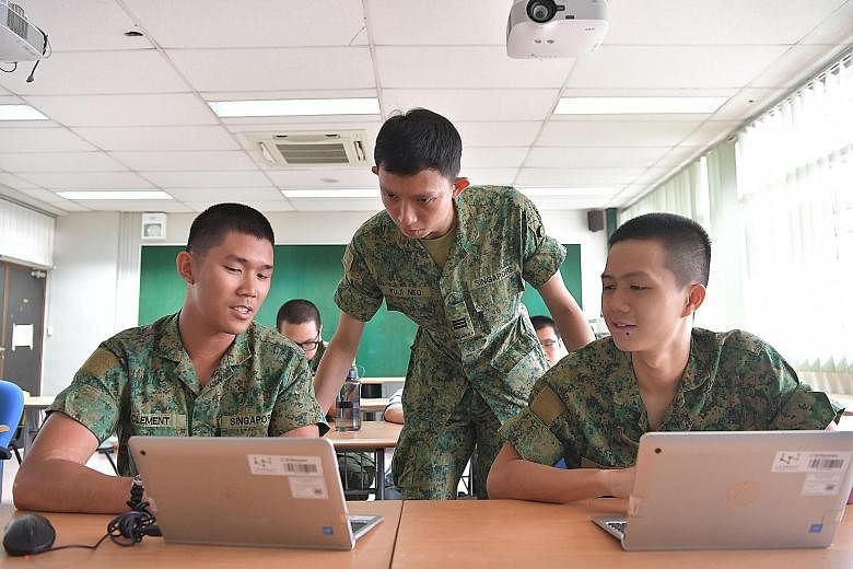 Private Clement Chin (left) presenting his work to Cyber Defence School trainer Fuji Neo (standing) in December. Pte Chin is in the pioneer cohort of NSF cyber specialists.