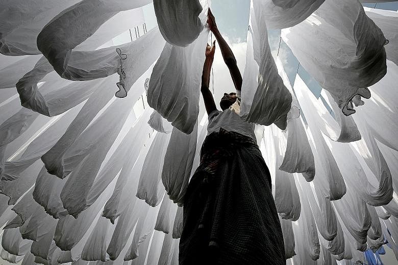 A worker sunning fabric at a dye factory in Bangladesh. In 2017, Bangladesh was the world's second-largest apparel supplier after China, with 6.5 per cent of the market. But its growth is threatened by automation, which is making textile manufacturin