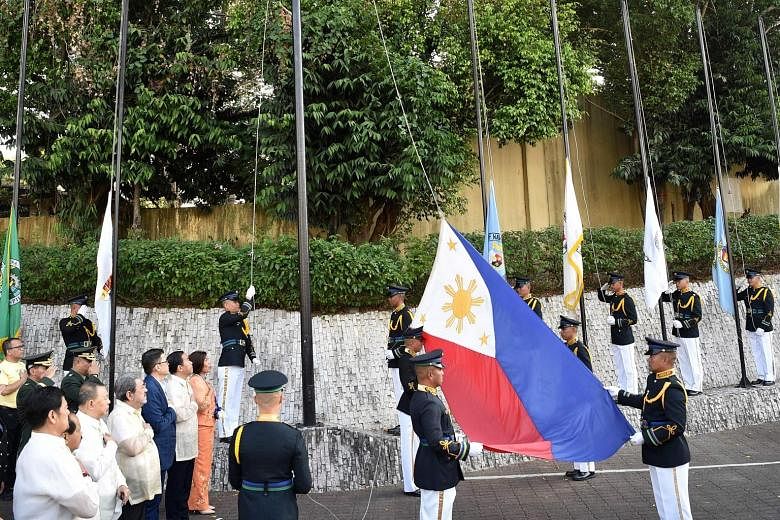 Philippine military personnel at a flag-raising ceremony to commemorate the 33rd anniversary of the People Power movement in Manila yesterday. The 1986 revolt toppled dictator Ferdinand Marcos from power, sending his family into exile in Hawaii.