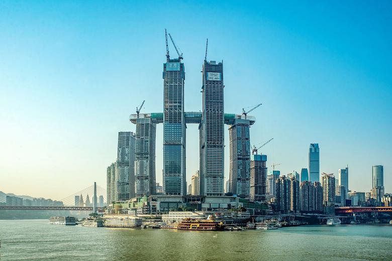 The 1.12 million sq m megastructure Raffles City Chongqing (left) is on track to open in the second half of this year in the Chinese city. The eighth and final skyscraper of the development was topped out on Jan 25, marking a milestone for Singapore-
