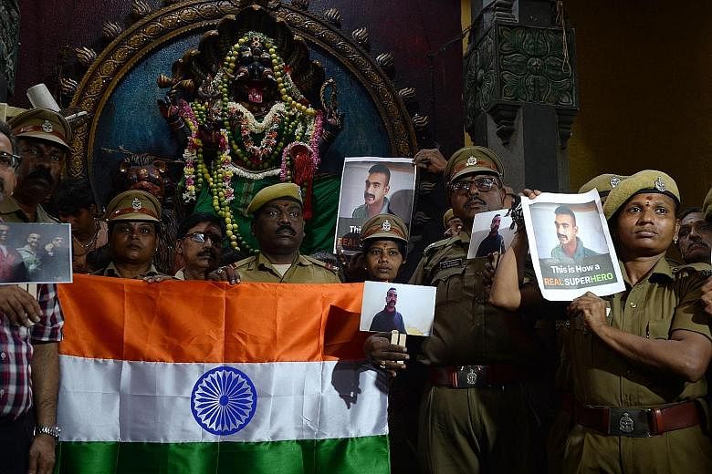Indian security forces holding up photos of pilot Abhinandan Varthaman during an event to pray for his return in Chennai yesterday.