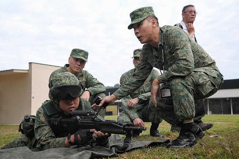 The Army Safety Inspectorate's Major Simon Chew (at right) carrying out an inspection observed by Singapore Armed Forces Inspector-General Tan Chee Wee (far left, behind) at Pasir Laba Camp on Thursday.