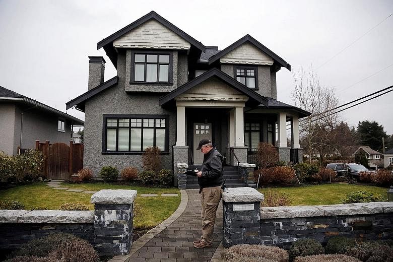 A member of a private security firm outside the family home of Huawei's chief financial officer Meng Wanzhou, in Vancouver, Canada, in January this year. Meng, the daughter of company founder Ren Zhengfei, was detained in December at Washington's req