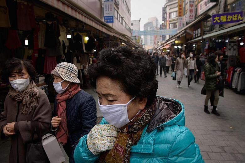 Shoppers wearing face masks as heavy air pollution hit Seoul yesterday. President Moon Jae-in has ordered the government to take extraordinary measures to fight fine dust pollution.