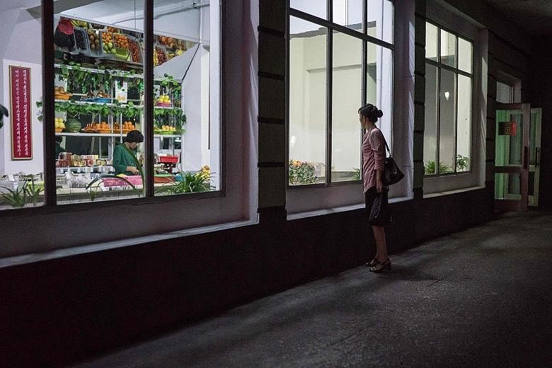 A 2017 photo of a woman outside a grocery store in Pyongyang. Natural disasters and inefficient agriculture in North Korea contributed to a plunge in food production last year, the UN says.
